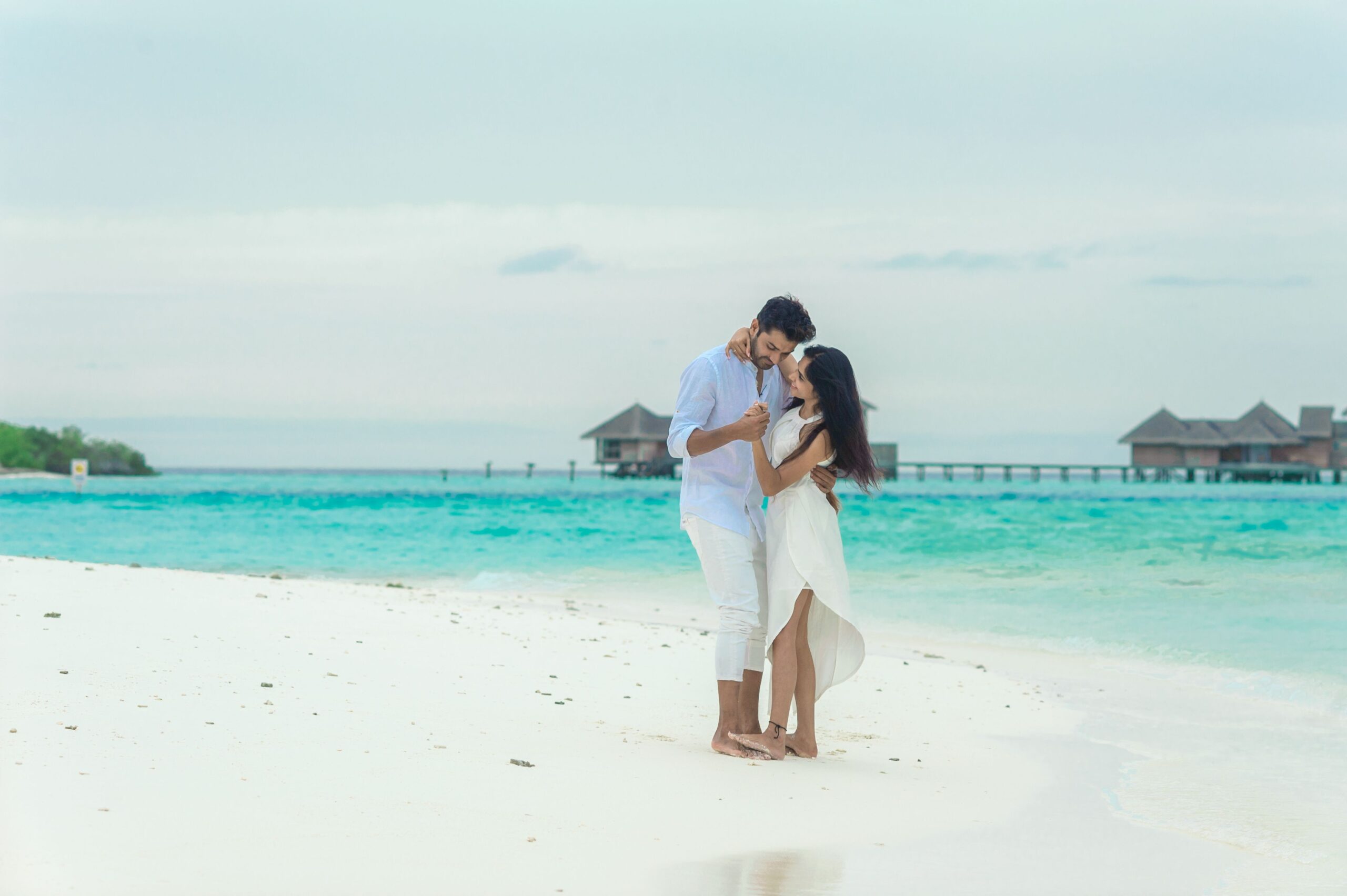 A couple embracing on a serene Maldives beach, epitomizing romantic getaway vibes.